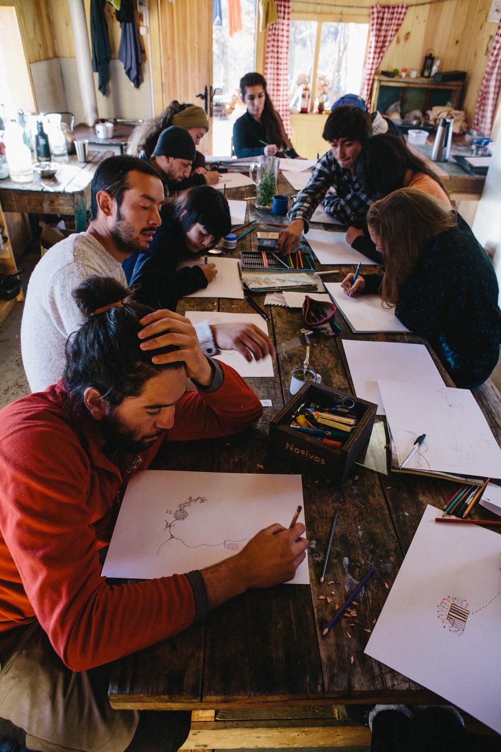 Estudiantes dibujan en una mesa del refugio