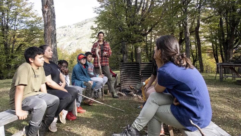 Estudiantes en círculo con una educadora en el bosque de Parque Escuela Kaikén