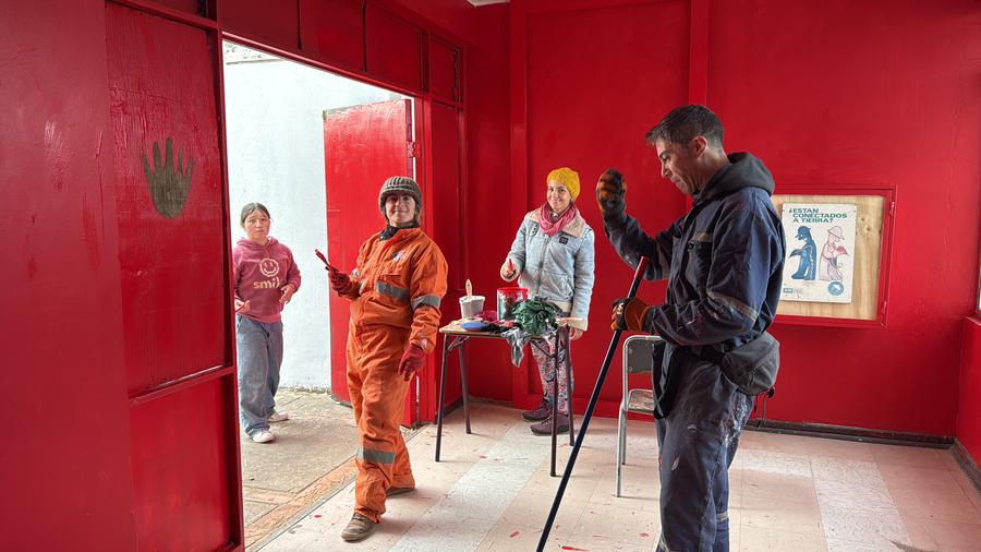Estudiantes y un educador pintan de rojo las paredes del futuro taller